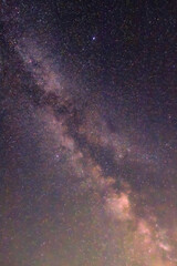 A band of the Milky Way weaves across the deep night sky, threading countless stars into an intricate cosmic tapestry. The sheer density glows like veins of light in space.