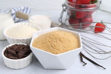 Different ingredients for panna cotta. Milk, sugar, vanilla, chocolate and strawberries on white table, closeup