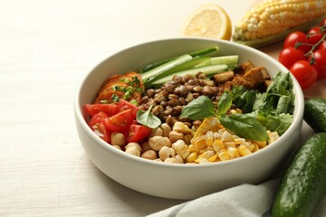 Healthy vegetarian food. Delicious Buddha bowl and ingredients on light wooden table, closeup. Space for text