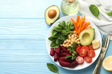 Different healthy vegetarian food served on light blue wooden table, flat lay. Space for text