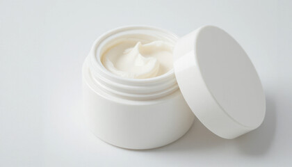 Open White Jar with Creamy Moisturizer Lid Beside It.