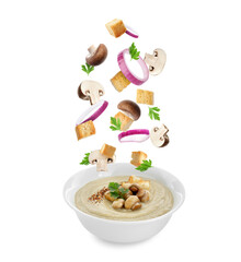 Croutons, onion rings and mushrooms falling into bowl of soup against white background