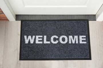 Welcome mat on floor near front door, top view
