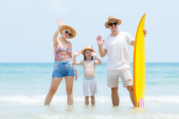 Caucasian family including father, mother, and daughter are delightful enjoy with beach vacation...
