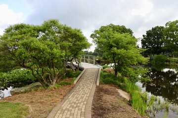 The walkway to the footbridge in the park on a sunny day.