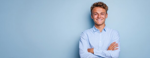 The cheerful young man smiling confidently against a blue background