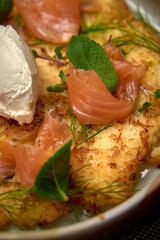 Deliciously Plated Dish Featuring Golden Crispy Hash Brown Base Topped with Smoked Salmon, Fresh Herbs, and Creamy Soft Cheese for an Elegant Culinary Experience