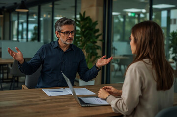 Fototapeta premium A tense business meeting with frustrated expressions discussing issues with diffused office lighting