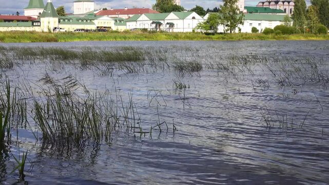 View from the water at Valdai Iversky Svyatoozersky Virgin Monastery for Men. Selvitsky Island, Valdai Lake. View of the Valdai Iversky Bogoroditsky svyatoozersky monastery. Sunny June day,