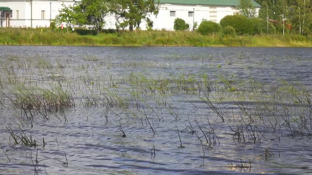 View from the water at Valdai Iversky Svyatoozersky Virgin Monastery for Men. Selvitsky Island, Valdai Lake. View of the Valdai Iversky Bogoroditsky svyatoozersky monastery. Sunny June day,