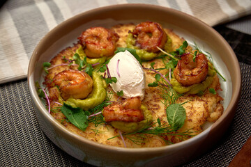 Deliciously Composed Shrimp Dish with Creamy Avocado Sauce and Garnished with Fresh Herbs for a Flavorful Culinary Experience