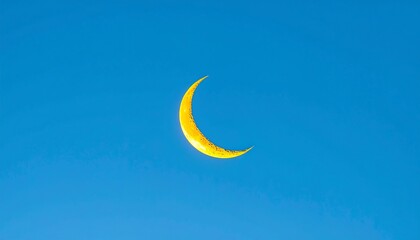 Golden crescent moon in a vibrant blue sky