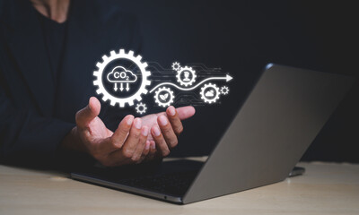 A person holds a digital icon depicting carbon dioxide reduction and sustainability, emerging from a laptop in a dark setting.