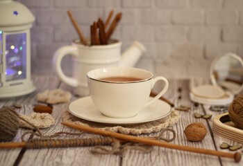Knitting process, needles, cup of tea and different objects on the table beautiful photo