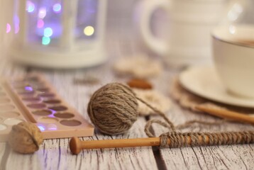 Knitting process, needles, cup of tea and different objects on the table beautiful photo	
