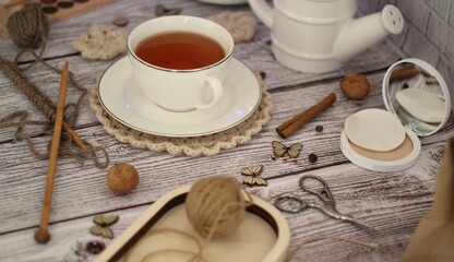Knitting process, needles, cup of tea and different objects on the table beautiful photo 