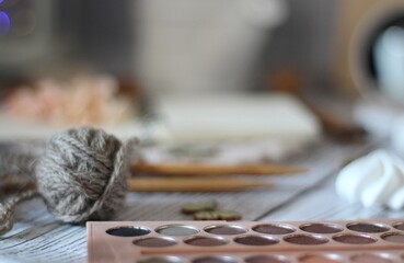 Knitting process, needles, cup of tea and different objects on the table beautiful photo	
