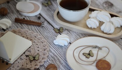 Cup of coffee, meringues, notepad diary and different woman things handmade art decor on wooden background table cozy photo 