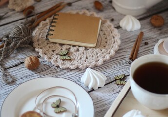 Cup of coffee, meringues, notepad diary and different woman things handmade art decor on wooden background table cozy photo 