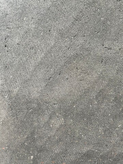 Surface of gray cement plaster closeup, grunge rough concrete texture as a background. Layers of exterior coarse sandy stucco. Old facade wall, cracked and patched finish with uneven smears pattern.
