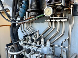Fishing vessel crane equipment showing intricate stainless steel piping systems, gauges, valves,...