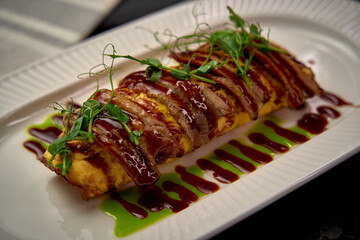 A Deliciously Crafted Dish Featuring a Soft Omelette Topped with a Rich, Savory Sauce and Garnished...