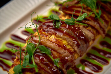 A Deliciously Presented Dish Featuring Savory Ingredients Drizzled with a Rich Sauce and Garnished...