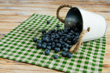 Fresh Blueberries Spilled from a Bucket on Green Checkered Cloth