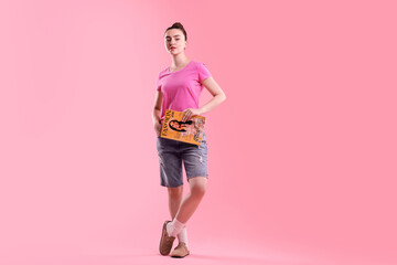 Woman with fashion magazine on pink background