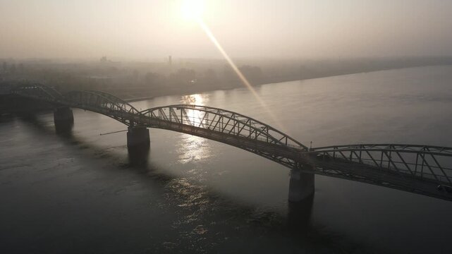 Drone video of the bridge over the Danube River in the city of Kom&aacute;rno, which connects Slovakia and Hungary. Aerial footage of the river, bridge and autumn landscape with fog.