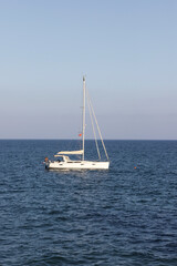 A small sailing ship on the sea at the horizon