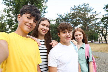 Group of teenagers taking selfie in park