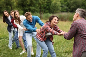 Team building. Group of happy people holding hands outdoors