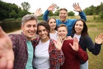Team building. Group of happy people taking selfie outdoors