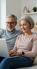 Happy Elderly Couple Enjoying Technology And Using A Laptop Together Indoors