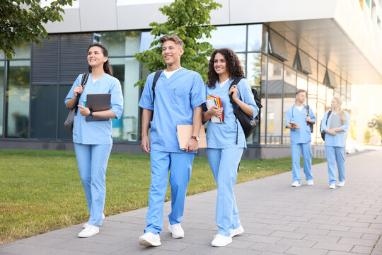 Medical students in uniforms walking near building outdoors