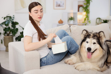 Woman suffering from allergy with her dog at home