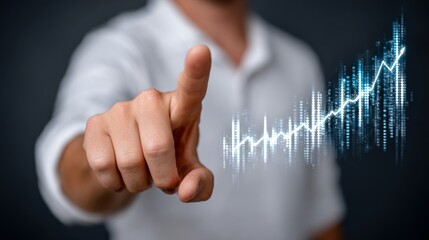 Man is pointing at a graph with a blue line. The graph shows a rising trend. The man is wearing a white shirt and is looking at the graph with interest
