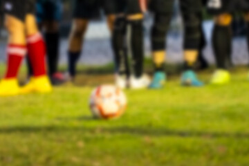 Blur background of the soccer ball on a grassy field