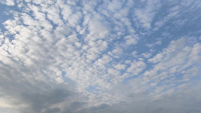 Dynamic altocumulus and stratus clouds paint the vast sky over Dnipro, Ukraine, on a tranquil evening. A beautiful contrast of light and shadow, highlighting nature's artistry above.