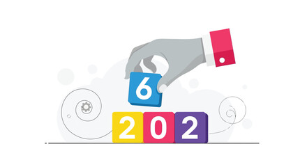 A hand placing a '6' block on a 2026 block, symbolizing a new year's beginning.