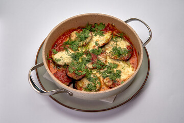Deliciously Baked Dish with Layered Vegetables and Cheese Topped with Fresh Herbs in a Round Baking Dish