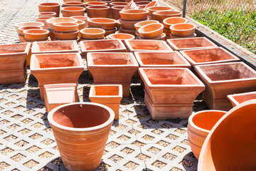 Square and round terracotta pots in outdoor display