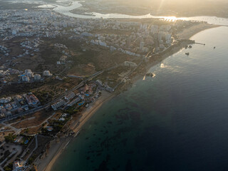 Aerial drone view of Praia da Rocha in Portimão, Algarve, Portugal, with golden cliffs, turquoise sea, and beachgoers enjoying the summer sun.
