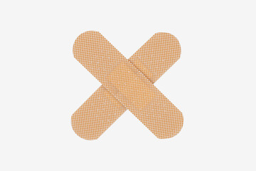Crossed adhesive bandages in X shape. Medical concept for no, stop, wrong, or health warning, isolated on white background with clipping path.