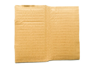 A piece of cardboard with a textured striped pattern, kraft paper for wrapping on a white background. The edges of the cardboard are torn and wavy brown. Top view of recycled cardboard texture.