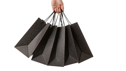 Hand holding set of luxury shopping bags against isolated background