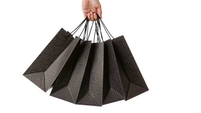 Hand holding set of luxury shopping bags against isolated background