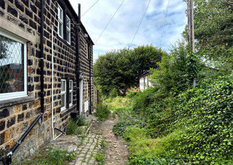 Victorian stone cottages and a winding cobblestone path, wrapped in greenery and quiet charm on, North Terrace, Yeadon, UK.