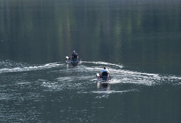 unrecognizable fishers on the fishing sup boards on the lake